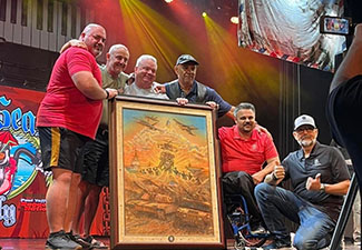 Artist Marc Lacourciere stands with warriors in front of his artwork, which was auctioned off on the High Seas Rally to raise money for Wounded Warrior Project's life-changing programs and services.