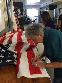 Veterans and their families show support for Chris Campbell by signing an American flag.