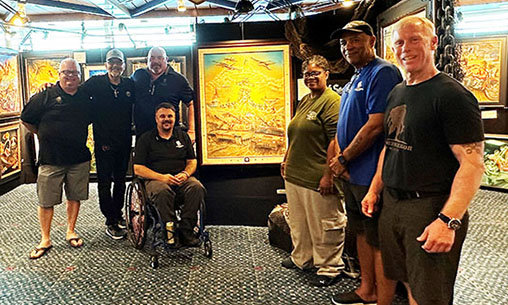 Artist Marc Lacourciere stands with warriors in front of his artwork, which was auctioned off on the High Seas Rally to raise money for Wounded Warrior Project's life-changing programs and services.