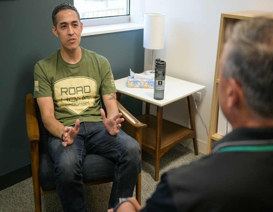 Warrior Sergio Alfaro attended Warrior Care Network's Road Home program at Rush University. He is talking to someone. 