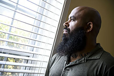 Veteran and warrior Eric DeLion, who may have CTE due to military service, looks out window